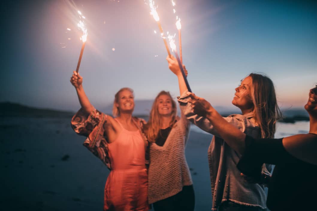 Women celebrating New Year's resolutions on beach