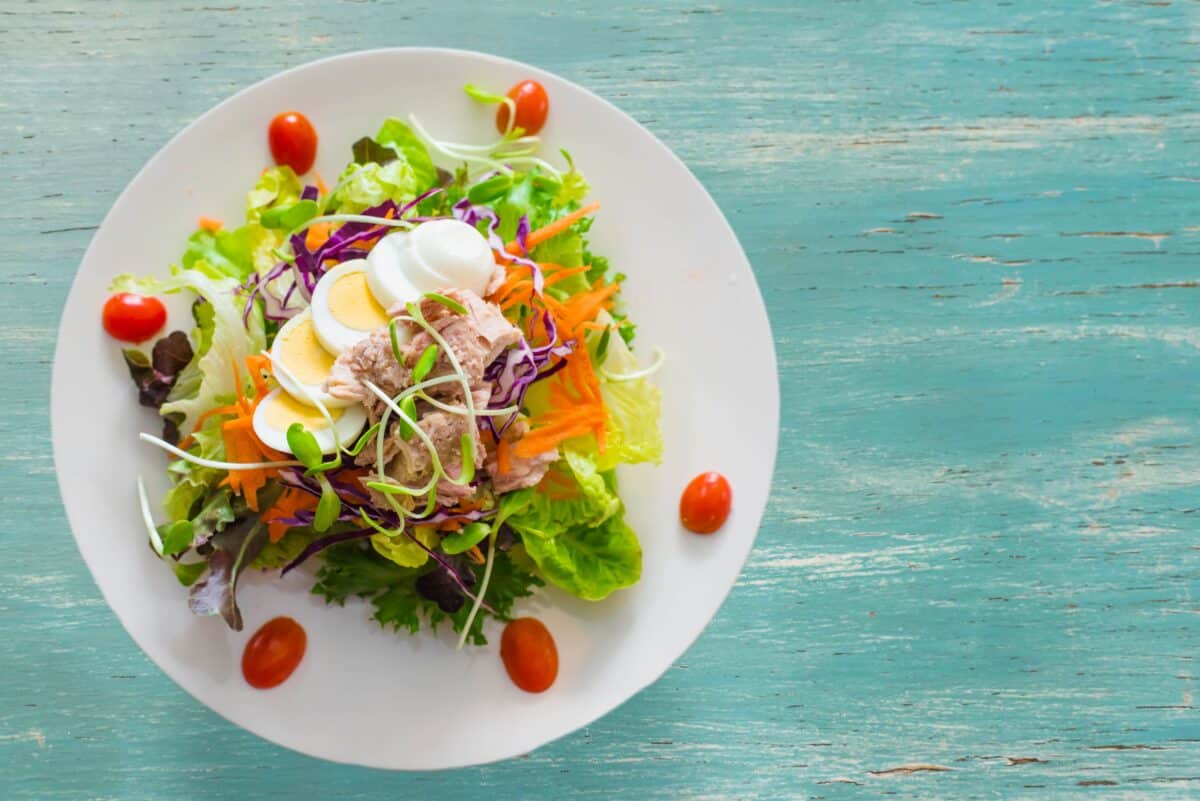 A healthy salad with carrots and egg on top